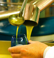 l'uscita dell'olio dal frantoio viene versato nel bicchiere blu adatto all'analisi sensoriale